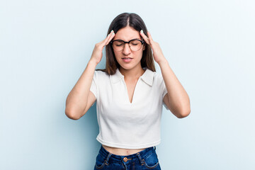 Young caucasian woman isolated on blue background touching temples and having headache.