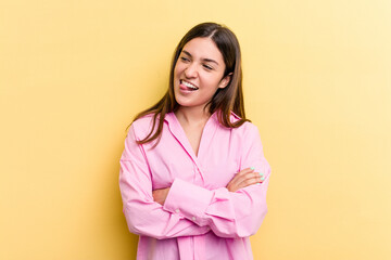 Fototapeta premium Young caucasian woman isolated on yellow background funny and friendly sticking out tongue.