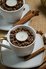 Tea candle in a cup with coffee beans. Aromatic tea candle.
