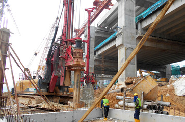 Fototapeta na wymiar KUALA LUMPUR, MALAYSIA -MARCH 30, 2022: Bore pile rig machine at the construction site. The machine used to driven pile for building foundation work. Operated by skilled workers. 