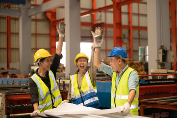 Teamwork co-workers Technicians and Engineer workers with hardhat or helmet, vest showing hands coordination and raising fist smiling for successful working in workplace of industry Factory