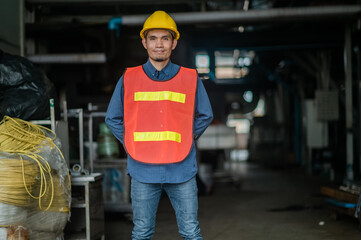 Confident Asian engineer standing in  factory , Asia worker employee in hard hat safety work in factory