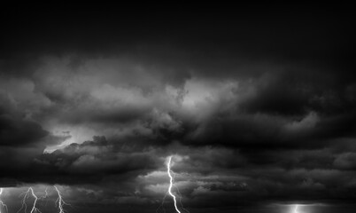 Fork lightning striking down during summer storm in black and white