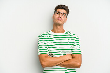Young caucasian man isolated on white background tired of a repetitive task.