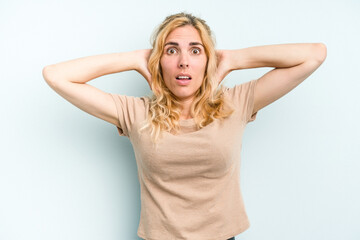 Young caucasian woman isolated on blue background screaming with rage.