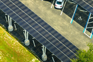 Aerial view of solar panels installed as shade roof over parking lot for parked cars for effective generation of clean electricity. Photovoltaic technology integrated in urban infrastructure