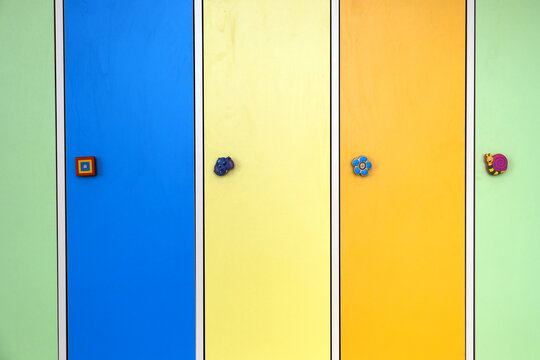 Close up of colorful lockers doors with funny animals as door knobs in day care school