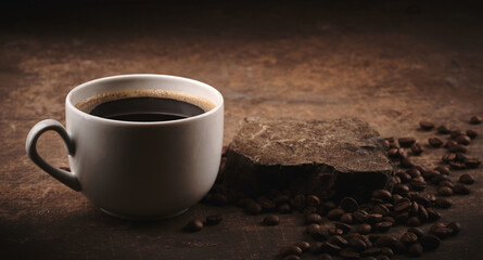 Fototapeta na wymiar Cup of freshly brewed roasted coffee beans on brown background