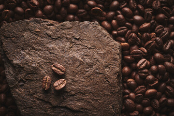 Roasted coffee beans on stone pedestal brown background