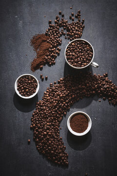 White cup of freshly brewed roasted coffee beans on gray background © amixstudio