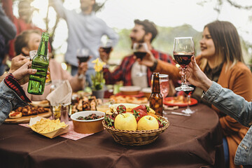 Happy people cheer at barbecue party in backyard - Young friends celebrating at dinner drinking red...