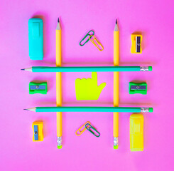 Neatly arranged pattern made of wooden pencils on pink background with school supplies. Creative flat lay, top view. Back to school concept with stationery.