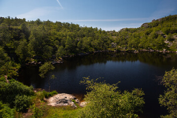 Fototapeta na wymiar Clear mirror-like mountain lake in the area around Pulpit Rock (Preikestolen), Savanger, Norway