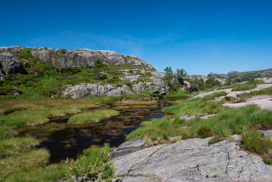 Clear mirror-like mountain lake in the area around Pulpit Rock (Preikestolen), Savanger, Norway