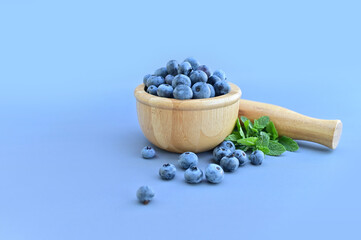 Freshly picked blueberries in a wooden bowl. Juicy and fresh blueberries. Blueberries on a wooden background. Antioxidant from blueberries. The concept of healthy eating and proper nutrition