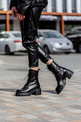 Women's legs close-up in black leather boots made of genuine leather.Collection of women's autumn shoes