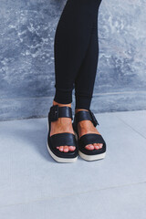 Women's legs close-up in black leather sandals made of genuine leather.Collection of women's summer...