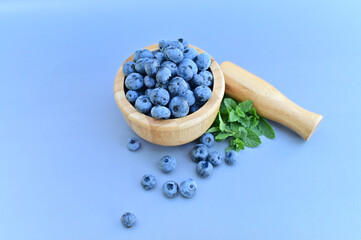 Freshly picked blueberries in a wooden bowl. Juicy and fresh blueberries. Blueberries on a wooden background. Antioxidant from blueberries. The concept of healthy eating and proper nutrition