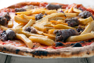 Deliziosa pizza condita con patatine fritte e salsiccia 
