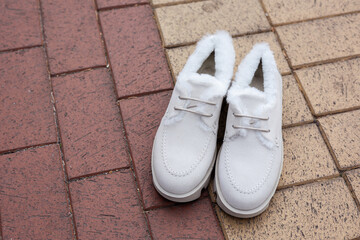 women's white leather shoes stand on a tile. Collection of autumn women's shoes