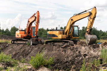 Crawler excavators dig the earth with a bucket. Drainage of swamps. Clearing the construction site....