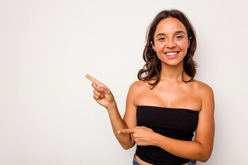 Young hispanic woman isolated on white background excited pointing with forefingers away.