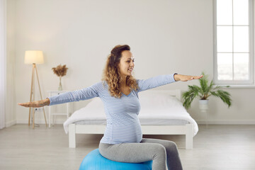 Happy healthy woman enjoying physio therapy exercises with a fit ball during pregnancy. Cheerful...