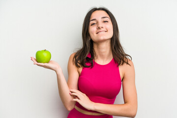 Fototapeta na wymiar Young caucasian woman holding an apple isolated on white background laughing and having fun.
