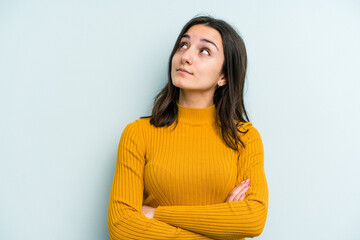 Young caucasian woman isolated on blue background dreaming of achieving goals and purposes