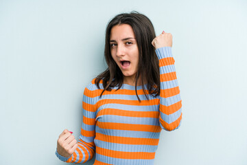 Young caucasian woman isolated on blue background cheering carefree and excited. Victory concept.