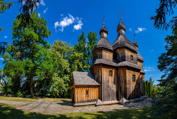 An old wooden church in Ukraine. Rural landscape with a church. Wooden Cossack Ukrainian church in the village of Zinkiv. - obrazy, fototapety, plakaty