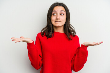 Young caucasian woman isolated on white background confused and doubtful shrugging shoulders to hold a copy space.