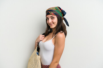 Young caucasian woman wearing a beach bag isolated on white background