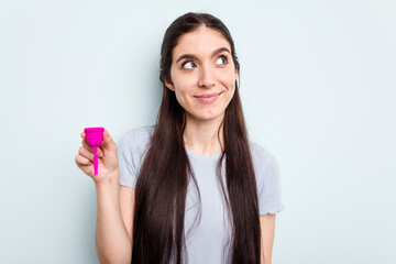 Young caucasian woman holding a sanitary napkin isolated on blue background dreaming of achieving goals and purposes