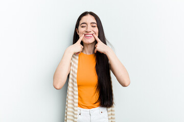 Young caucasian woman isolated on white background smiles, pointing fingers at mouth.