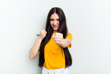 Young caucasian woman isolated on white background showing fist to camera, aggressive facial expression.