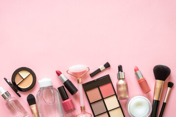 Makeup professional cosmetics on pink background. Cream, lipstick, shadow and brushes. Flat lay...