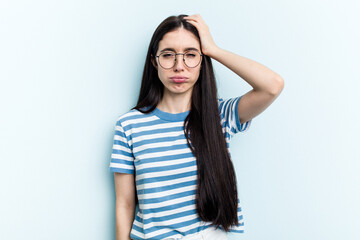 Young caucasian woman isolated on blue background tired and very sleepy keeping hand on head.