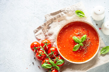 Tomato soup with spices and basil. Cold summer soup. Top view on white background.