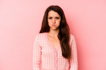 Fototapeta premium Young caucasian woman isolated on pink background blows cheeks, has tired expression. Facial expression concept.