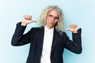 Middle age caucasian business woman isolated on blue background feels proud and self confident,...