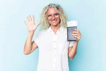 Middle age caucasian woman holding a passport isolated on white background smiling cheerful showing number five with fingers.