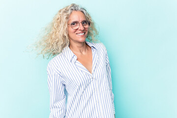 Middle age caucasian woman isolated on blue background dancing and having fun.