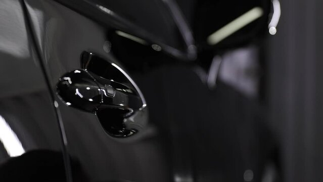 Car service worker applying nano coating on a car detail.
