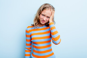 Caucasian teen girl isolated on blue background tired and very sleepy keeping hand on head.