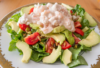 Prawn in a seafood sauce and succulent red tomatoes in a salad with avocado and lettuce.