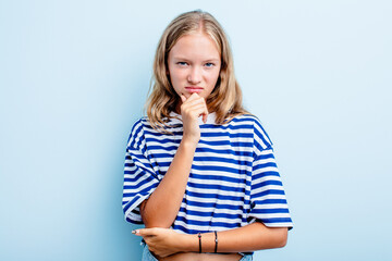 Caucasian teen girl isolated on blue background thinking and looking up, being reflective, contemplating, having a fantasy.