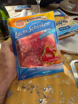Frankfurt, Germany - Jan 1, 2022: POV male hand holding plastic package with Kleinemas Lachsschinken - salmon ham with under 3 percent fat