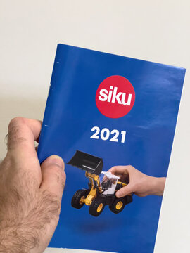 London, United Kingdom - Jan 3, 2022: POV male hand holding new catalogue for the brand SIKU - German manufacturer of scale models headquartered in Ludenscheid