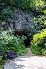 Overgrown entrance in one of the tunnels for aircrafts under the mountain in the abandoned and...